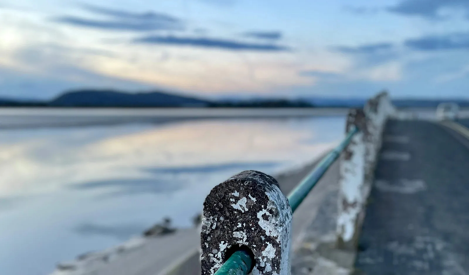 A railing post on the promenade at Arnside, near Carnforth, with the estuary at dusk behind